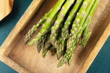 Mutfak arka planında bir sürü çiğ kuşkonmaz. Vejetaryen yemeği. Yemek fotoğrafçılığı. Yeşil kuşkonmaz.
