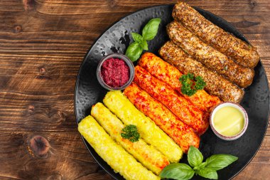 Ahşap arka planda ızgara sosis, sıcak baharat, hardal ve kokulu sos karışımı..