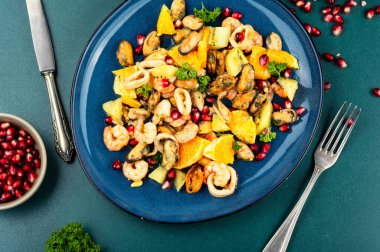 Karışık deniz ürünleri salatası, portakal, kivi ve nar tohumları. Lezzetli ve sağlıklı yemekler..