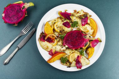 Olgun pitahaya meyvesiyle pişirilmiş zarif beyaz balık filetosu. Genel Görünüm.