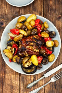 Fırında pişmiş domuz rustik ahşap masada sebzelerle pişirilmiş..