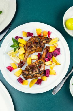 Limon, ananas ve ejderha meyvesiyle servis edilen lezzetli pişmiş ördek bacakları. Düz yatıyordu.