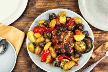 Patates, mantar, biber ve ahşap arka planda patlıcanla pişirilmiş lezzetli domuz eti. Üst görünüm.