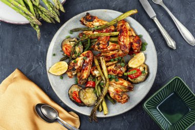 Bir tabak tavuk kanadı bbq kuşkonmaz ve patlıcan..