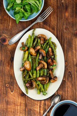 Vejetaryen yemeği. Kızarmış yeşil kuşkonmaz ve şampiyon..