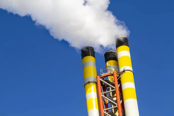 煙を放出し 澄んだ青空に対して空気を汚染するごみ焼却炉から煙突の動的角度 — ストック写真