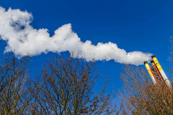쓰레기 소각로에서 나오는 굴뚝의 동역학적 연기를 방출하고 하늘을 배경으로 공기를 로열티 프리 스톡 사진