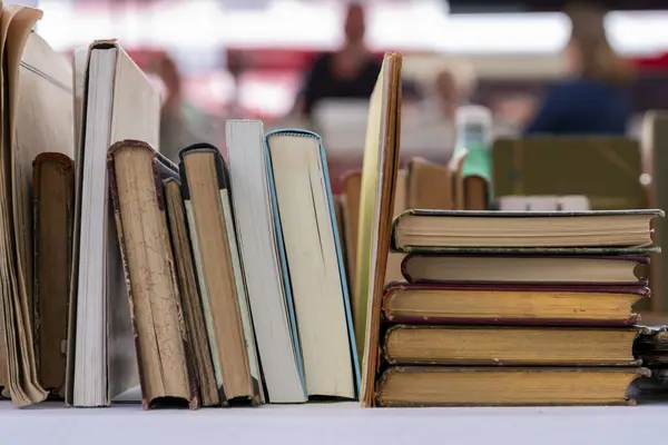 Stock image Books on a market stall at the annual book fair in Dordrecht offer a diverse selection of genres and authors, attracting avid readers and collectors with rare finds and popular titles in a charming historic setting.