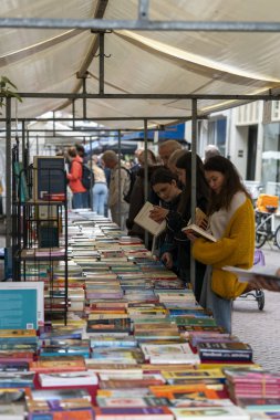 Dordrecht, Netherlands - July 7, 2024: Visitors explore second-hand books at the annual book market in Dordrecht, 350 stalls throughout the city centre, where booksellers offer their best books. clipart