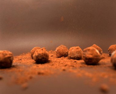 Tahta zemin üzerinde kakao tozu olan çikolatalı mantarlar.