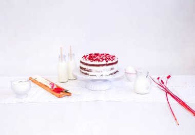 Kırmızı mumlarla süslenmiş bir Noel süsü beyaz bir tabakta, arka planda.