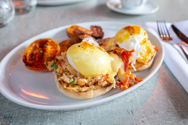Lobster Benedict Served with Roasted Potatoes and Tomatoes