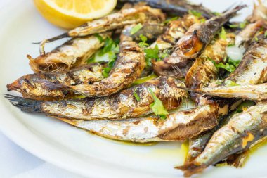 Yunanistan 'da bir restoranda bir dilim limonla servis edilen bir tabak dolusu ızgara sardalya.