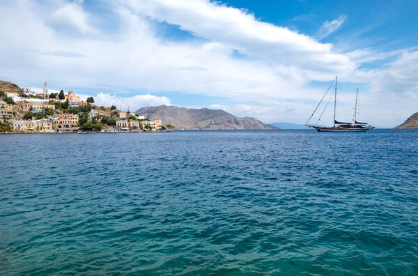 A Big Sailboat Approaching the Harbor of Symi, Greece, on a Calm Sea