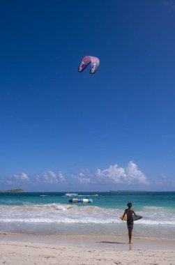 Orient Beach, Saint Martin: 12 Kasım 2023: Sahilde sörf yapan sörf yapan bir çocuğun geriye bakışı
