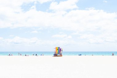 Miami Beach Florida 'daki Gökkuşağı Cankurtaran Kulesi' nde Kum, Deniz ve Gökyüzü 'nün Pastel Arkaplanı ve Kıyıya Dağılan Çok Az Kişi Var