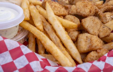 Deep Fried and lightly Battered Pickerel Nuggets Served with Fries, Tartar Sauce and Coleslaw clipart