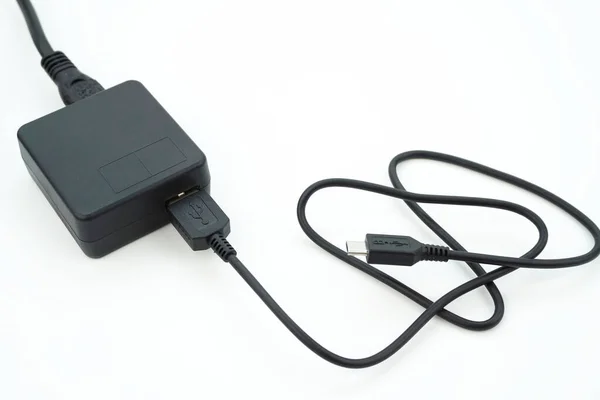 插在适配器电缆上给摄像机充电 这是一种用于各种电子设备的充电器电缆 — 图库照片