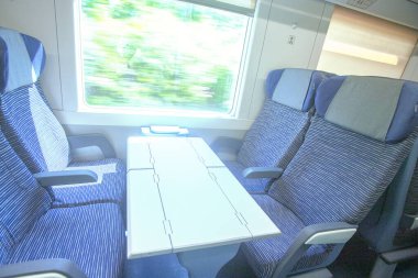Photography of the interior of a train during a trip window and landscape during the afternoon inside a wago