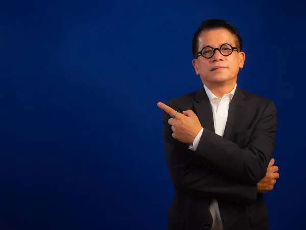 演播室里聪明的亚洲中年自信的成功商人穿着西服 手指尖 背景为蓝色 看上去有吸引力 专业领导积极 — 图库照片