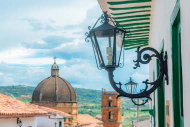 Barichara Santander 'in koloni caddesinde ön planda fener ve arka planda katedral var.