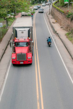 San Gil, Santander, Colombia, April 26, 2024, landscape of Santander Avenue in San Gil with heavy cargo traffic, and a tractor-trailer in the foreground clipart