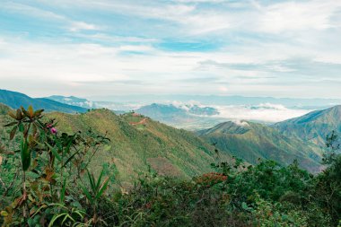 Kolombiya dağlarının manzarası. Güneşli bir günde gün doğumunda ekinler ve bulutlu mavi gökyüzü.