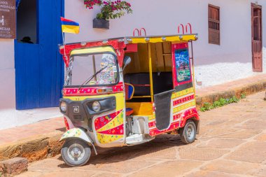 Barichara, Santander, Kolombiya, 11 Ekim 2024. Canlı renkler ve karnaval süslemeleriyle boyanmış bir mototaxi (rickshaws-Tuk-tuk), Barichara 'da turist turları için kullanılır.