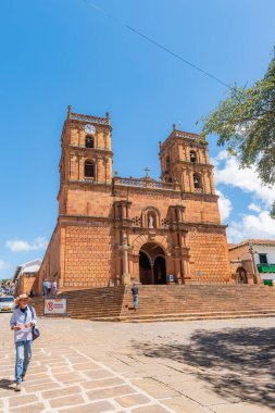 Barichara, Santander, Kolombiya, 11 Ekim 2024 Barichara katedralinin ana meydandaki dikey fotoğrafı. Bu tarihi bina taş ve kerpiç tekniklerinden yapılmıştır. Birçok turist güneşli günün ve mimarinin tadını çıkarırken görülebilir..