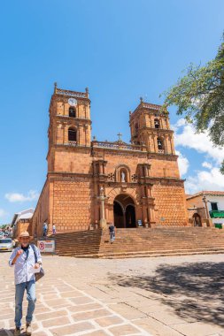 Barichara, Santander, Kolombiya, 11 Ekim 2024 Barichara katedralinin ana meydandaki dikey fotoğrafı. Bu tarihi bina taş ve kerpiç tekniklerinden yapılmıştır. Birçok turist güneşli günün ve mimarinin tadını çıkarırken görülebilir..