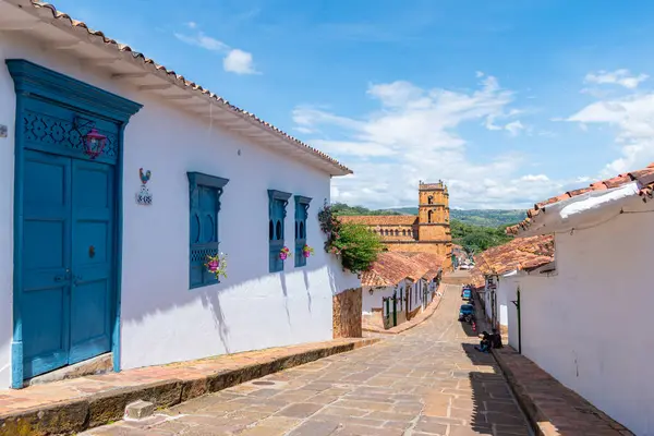 Barichara, Santander, Kolombiya, 11 Ekim 2024. Güneşli bir günde, Barichara 'nın parlak mavi gökyüzünün altında renkli koloni evleri olan kaldırım taşı sokağının manzarası şehrin cazibesini ve sükunetini yakalıyor..