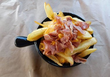 Fries with cheese and bacon, served in a restaurant