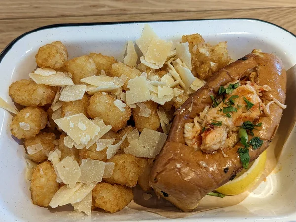 view of a lobster roll served with parmesan tots