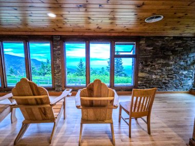 Adirondack sandalyeler ve dağların penceresinden bir manzara