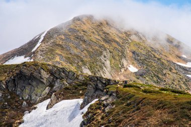Ukrayna Karpatlarının gökyüzü ve bulutların arka planında asılı duran Hoverla Dağı manzarası.