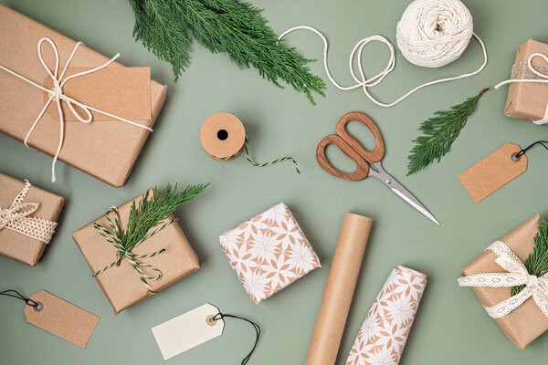 Christmas background with gift boxes and rolls of colored kraft wrapping paper. Xmas celebration, preparation for winter holidays. Festive mockup, top view, flatlay