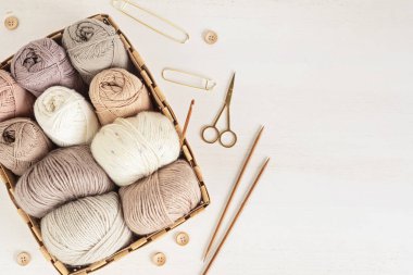 Craft knitting hobby background with yarn in natural colors. Recomforting hobby to reduce stress for cold fall and winter weather. Mock up, copy space, top view