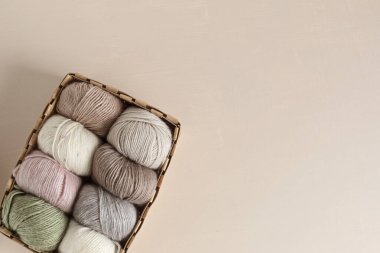 Craft knitting hobby background with yarn in natural colors. Recomforting hobby to reduce stress for cold fall and winter weather. Mock up, copy space, top view