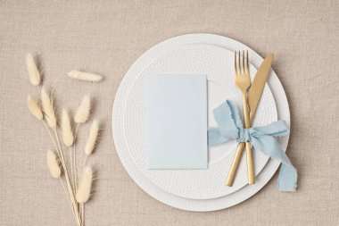 Festive wedding, birthday table setting with golden cutlery and porcelain plate. Blank card mockup. Party menu template. Flat lay, top view