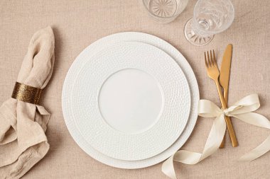 Festive wedding, birthday table setting with golden cutlery and porcelain plate. Empty plate mockup. Party menu template. Flat lay, top view