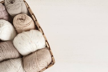 Craft knitting hobby background with yarn in natural colors. Recomforting hobby to reduce stress for cold fall and winter weather. Mock up, copy space, top view