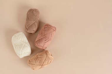 Craft knitting hobby background with yarn in natural colors. Recomforting hobby to reduce stress for cold fall and winter weather. Mock up, copy space, top view