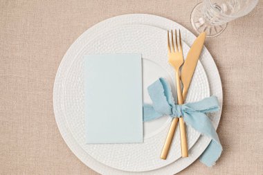 Festive wedding, birthday table setting with golden cutlery and porcelain plate. Blank card mockup. Party menu template. Flat lay, top view