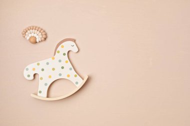 Cute rocking horse toy and teether on beige background. organic and eco friendly gifts for newborn baby