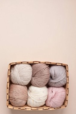 Craft knitting hobby background with yarn in natural colors. Recomforting hobby to reduce stress for cold fall and winter weather. Mock up, copy space, top view