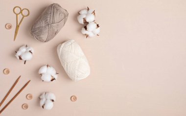 Craft knitting hobby background with yarn in natural colors. Recomforting hobby to reduce stress for cold fall and winter weather. Mock up, copy space, top view