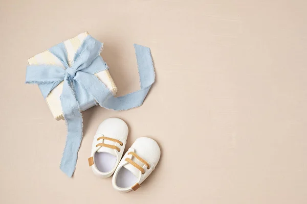 Baby shower, gender reveal, birthday party background with gift box and baby shoes. Top view, flatlay, copy space