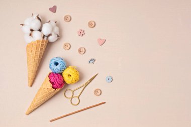 Colorful balls of organic cotton yarn waffle cones for ice cream . Recomforting hobby to reduce stress
