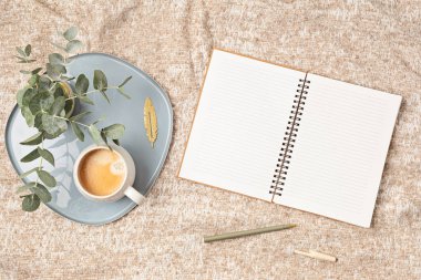 Mockup of notebook and coffee cup on beige plaid background, with copy space for text. Flat lay, top view photo mock up.