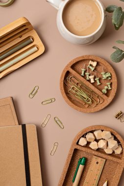 Bej arka planda geri dönüştürülmüş malzemelerden yapılmış ofis malzemelerinin düz hali ve metin için kopya alanı. Sancak, düz yatak, üst manzara 